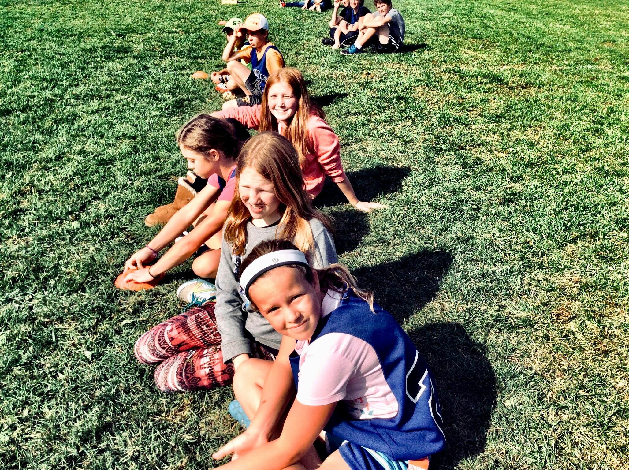 kids sitting on a grass field